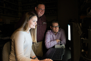 Julia Sunstrum, Stephen Lomber and Blake Butler examine images on a computer screen
