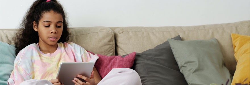 Photo of girl sitting on sofa while using tablet. Photo by Julia Cameron (Pexels)