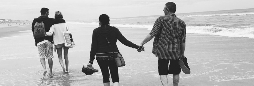 A pair of couples walks along the beach. (Photo from Pexels)