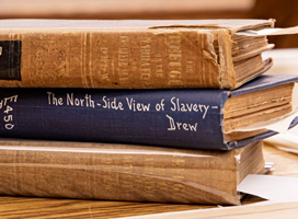 Stack of books, including Benjamin Drew's book "A North-Side View of Slavery" 